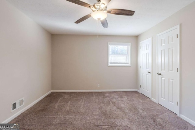 carpeted spare room featuring ceiling fan