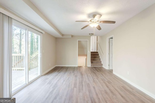 unfurnished room with ceiling fan, light hardwood / wood-style floors, and a textured ceiling