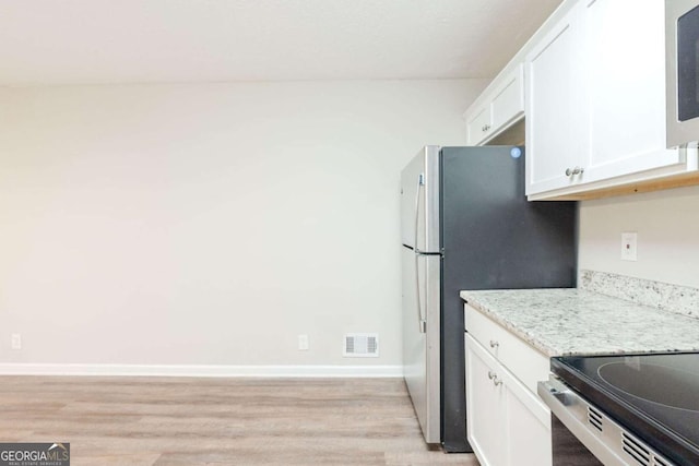 kitchen featuring white cabinetry, light stone countertops, and light hardwood / wood-style floors