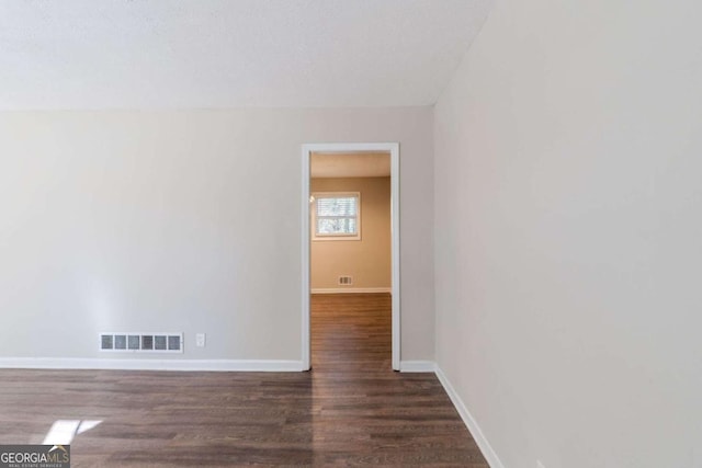 empty room with dark hardwood / wood-style flooring