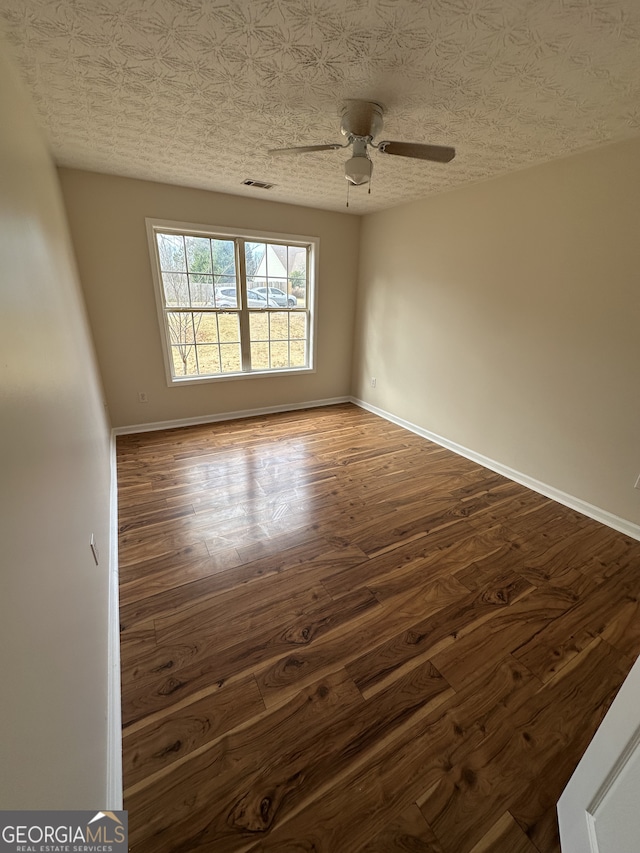 spare room with wood-type flooring, a textured ceiling, and ceiling fan