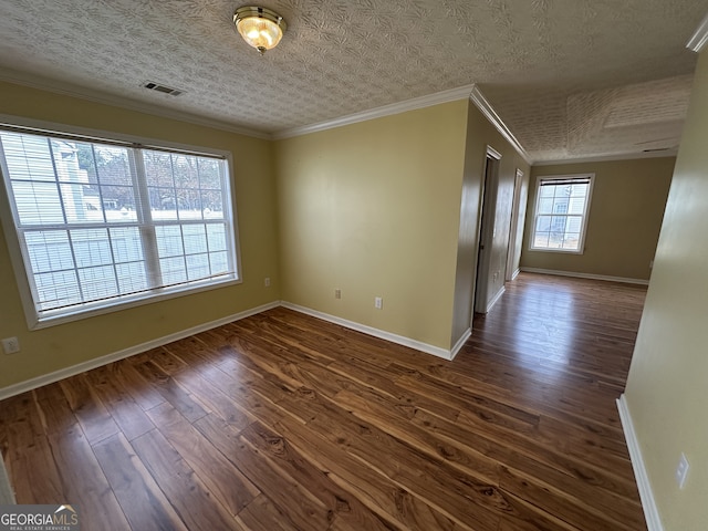 empty room with a textured ceiling, crown molding, and dark wood-type flooring