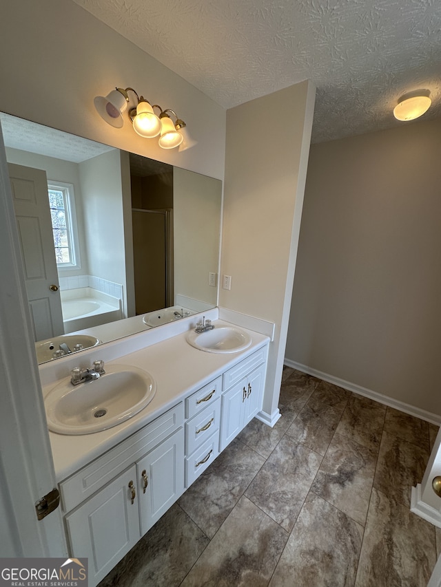 bathroom featuring vanity, a textured ceiling, and shower with separate bathtub