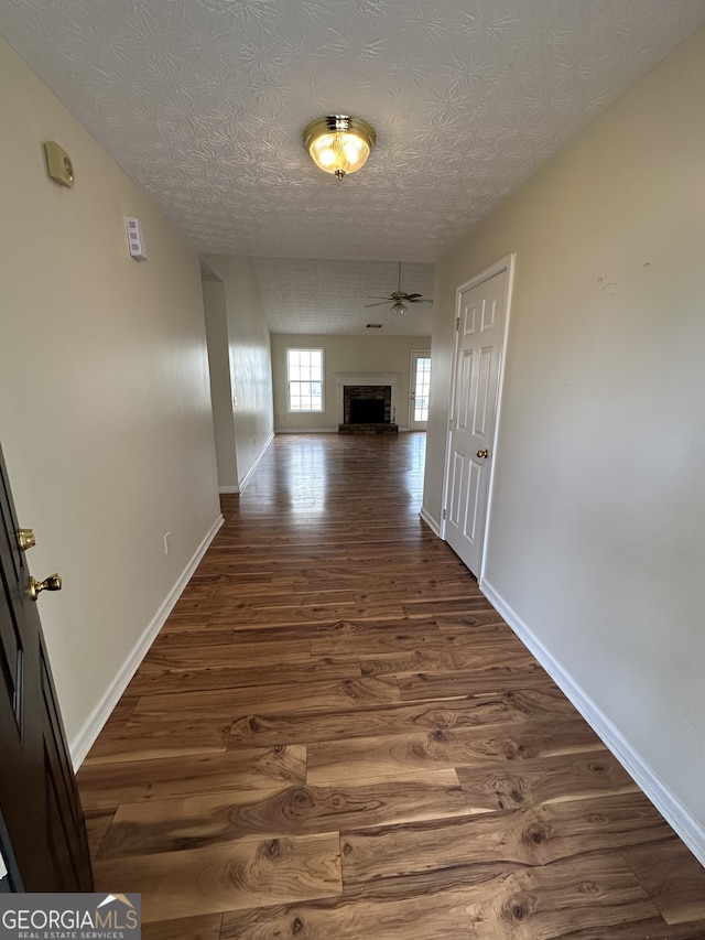 hallway featuring a textured ceiling and dark hardwood / wood-style floors