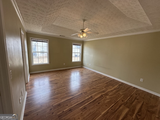 unfurnished room featuring a raised ceiling, crown molding, ceiling fan, and dark hardwood / wood-style floors