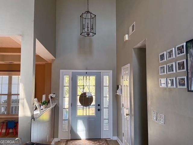 foyer featuring a towering ceiling and an inviting chandelier