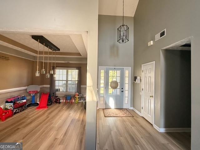 foyer entrance with wood-type flooring and a notable chandelier