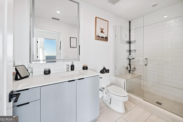 bathroom featuring toilet, vanity, visible vents, and a shower stall