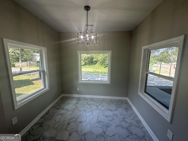 unfurnished room with an inviting chandelier