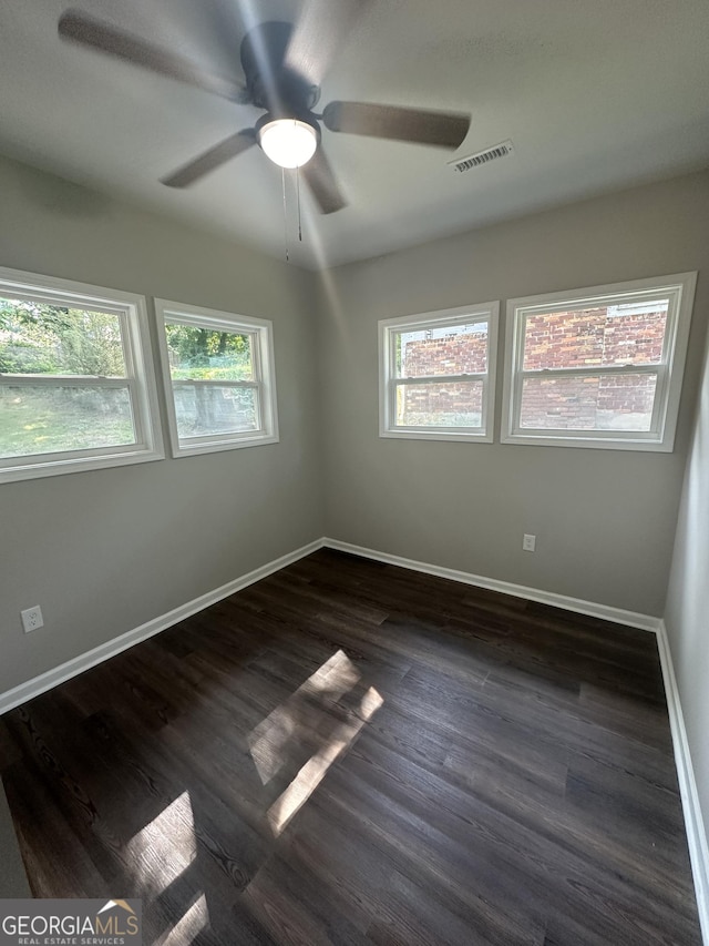 unfurnished room with ceiling fan and dark hardwood / wood-style flooring