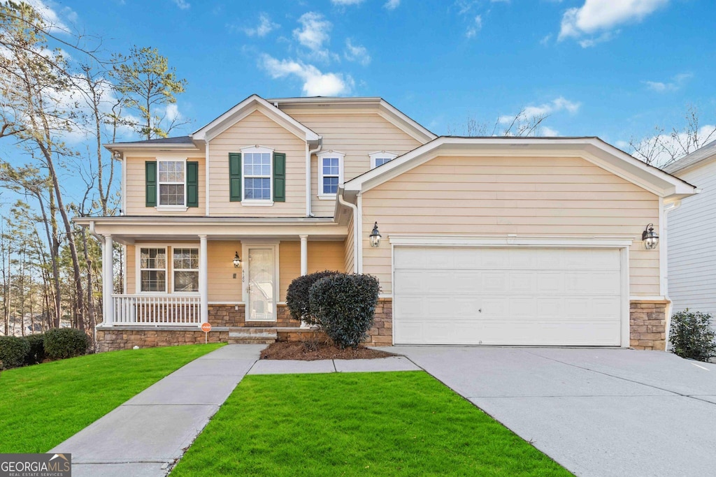 view of front facade with covered porch, a garage, and a front yard