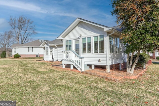 rear view of property featuring a yard