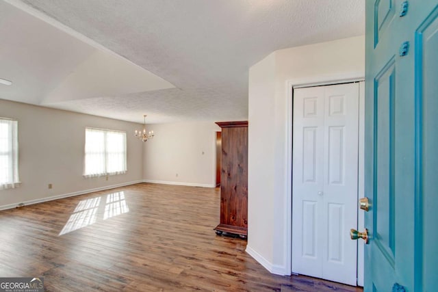 interior space with hardwood / wood-style floors, a textured ceiling, and a chandelier