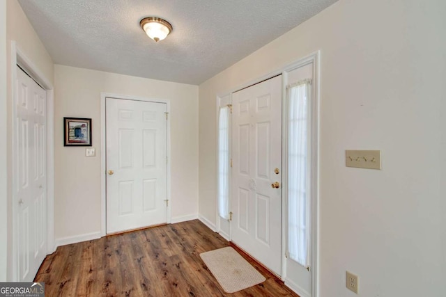 foyer with a textured ceiling and dark hardwood / wood-style floors