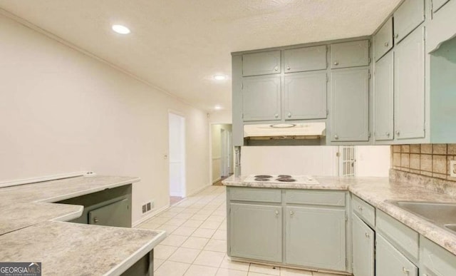 kitchen with backsplash, sink, white electric cooktop, light tile patterned flooring, and kitchen peninsula