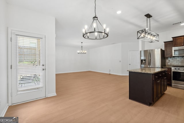 kitchen featuring stainless steel appliances, tasteful backsplash, hanging light fixtures, and a notable chandelier