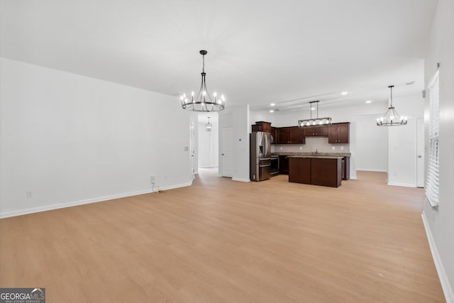 kitchen with an inviting chandelier, hanging light fixtures, a center island, and stainless steel refrigerator with ice dispenser