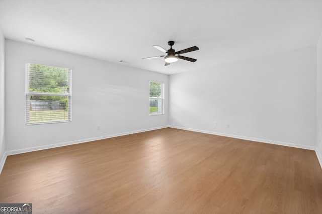 empty room with hardwood / wood-style floors and ceiling fan