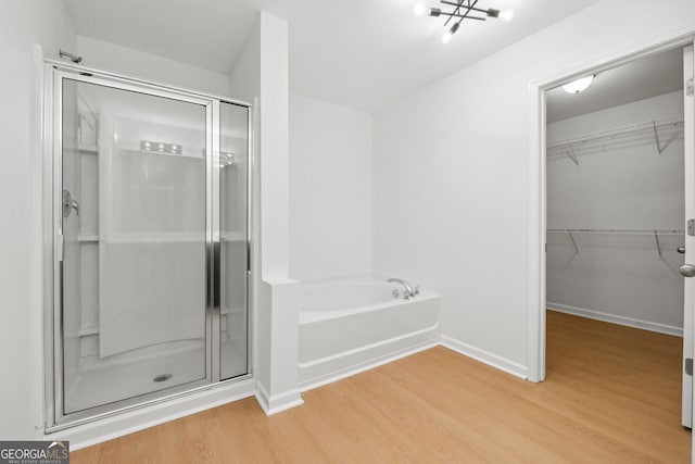 bathroom featuring wood-type flooring and plus walk in shower