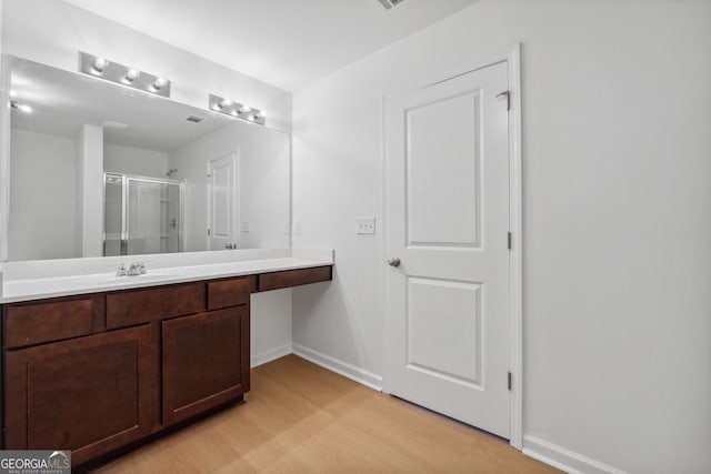 bathroom featuring wood-type flooring, vanity, and walk in shower