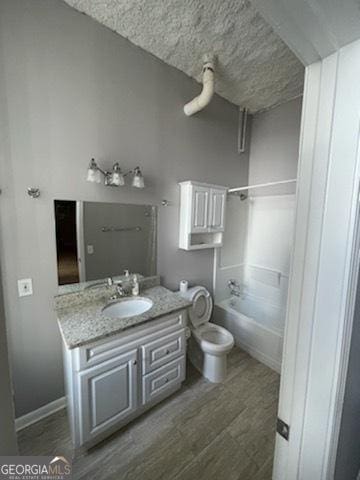 full bathroom with wood-type flooring, toilet, shower / bathing tub combination, and vanity