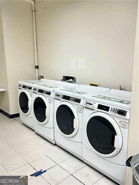 laundry room with light tile patterned floors and washer and clothes dryer