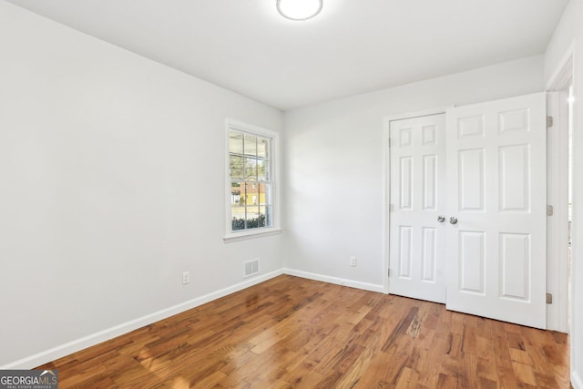 unfurnished bedroom featuring wood-type flooring and a closet