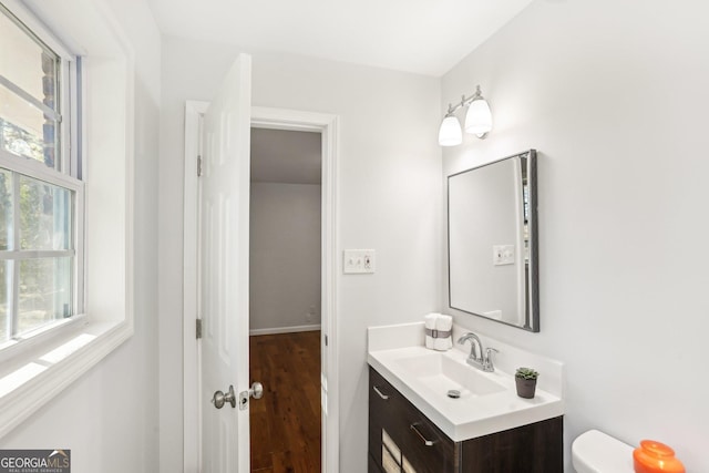 bathroom with hardwood / wood-style floors, vanity, and toilet