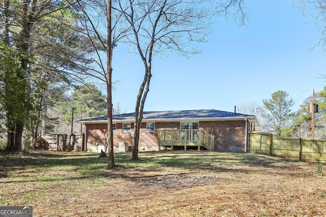 back of property with a lawn and a wooden deck