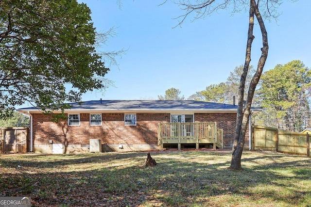 rear view of house featuring a deck and a yard