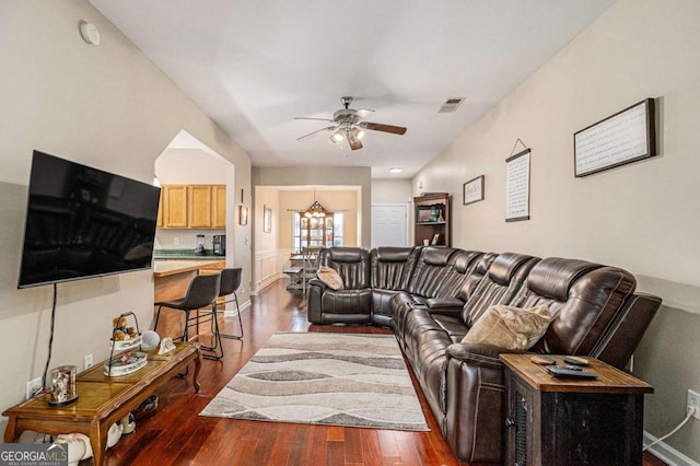 living room featuring ceiling fan with notable chandelier and dark hardwood / wood-style floors