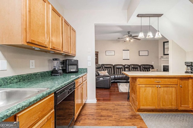 kitchen featuring ceiling fan, black dishwasher, dark hardwood / wood-style flooring, kitchen peninsula, and pendant lighting