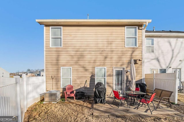 rear view of property with central AC unit and a patio