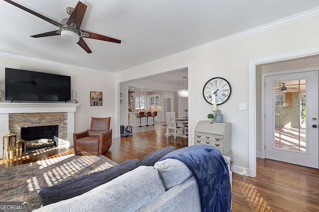 living room with ceiling fan, wood-type flooring, a fireplace, and ornamental molding