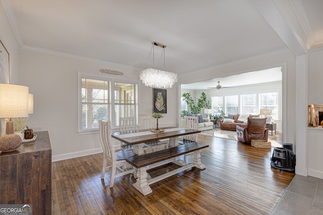 dining space featuring wood-type flooring, ceiling fan with notable chandelier, and crown molding