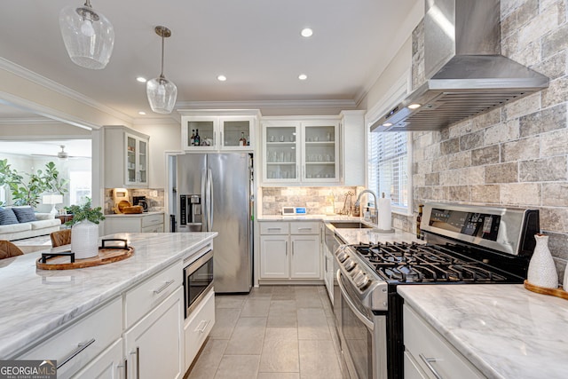 kitchen featuring white cabinetry, sink, wall chimney exhaust hood, hanging light fixtures, and stainless steel appliances