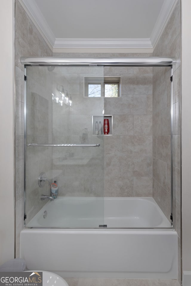 bathroom with ornamental molding and bath / shower combo with glass door