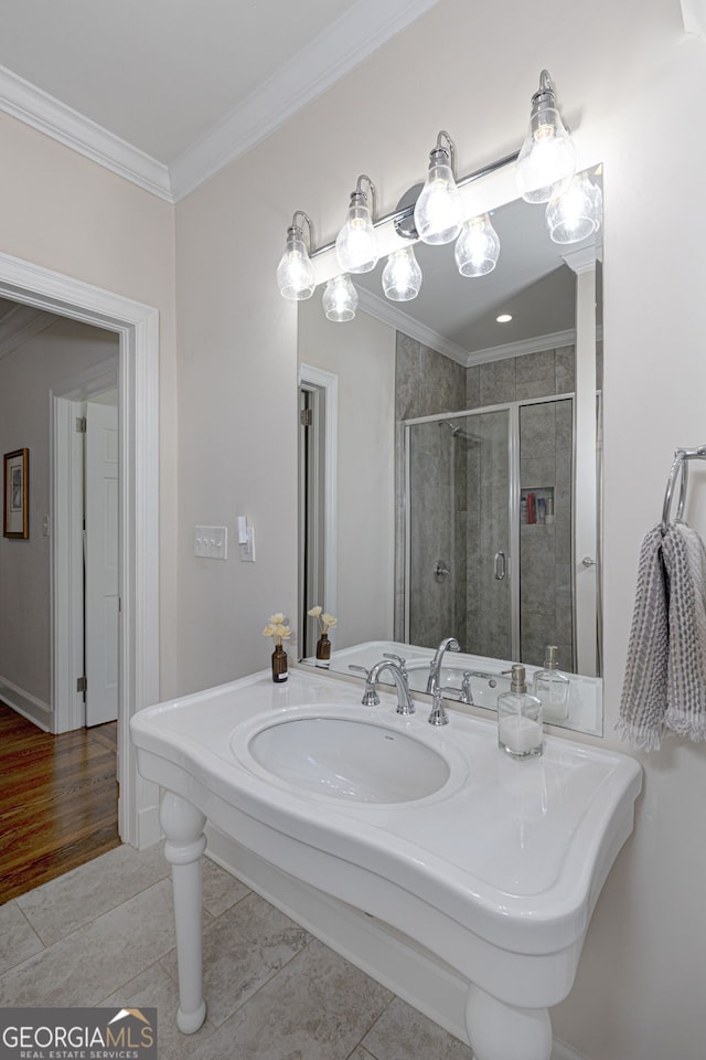 bathroom featuring tile patterned floors, sink, a shower with door, and ornamental molding