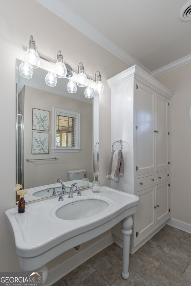 bathroom with toilet, crown molding, and walk in shower