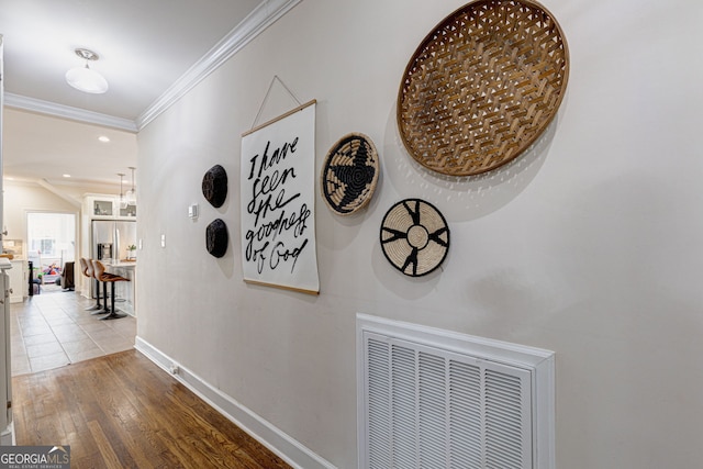 corridor featuring light hardwood / wood-style floors and crown molding