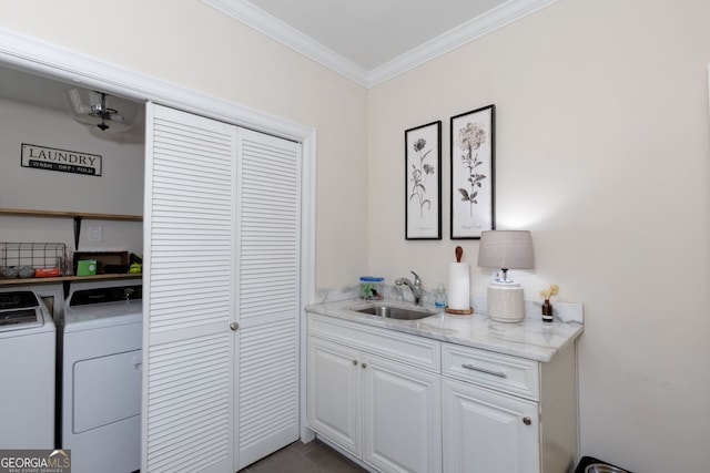 laundry area with washer and dryer, crown molding, dark tile patterned floors, and sink