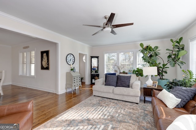 living room featuring a wealth of natural light, dark hardwood / wood-style flooring, ceiling fan, and ornamental molding