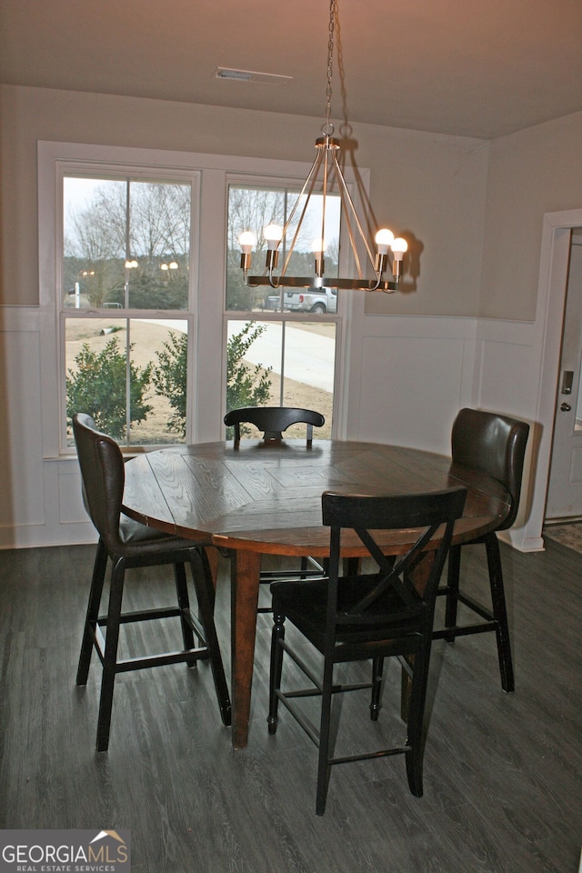 dining area with a notable chandelier and dark hardwood / wood-style flooring