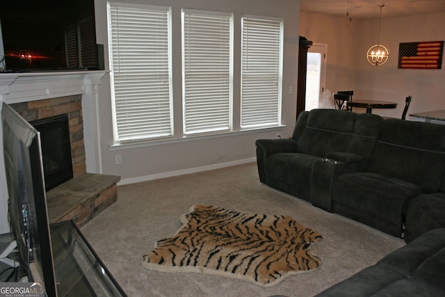 carpeted living room with a fireplace and an inviting chandelier