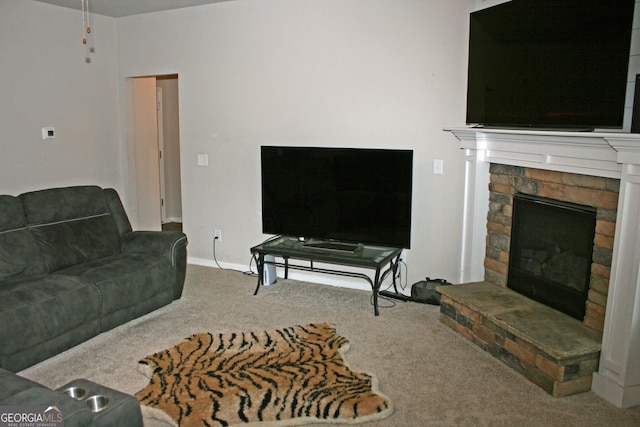 carpeted living room featuring a stone fireplace