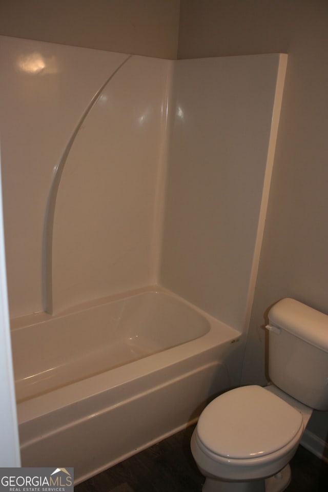 bathroom featuring shower / washtub combination and toilet