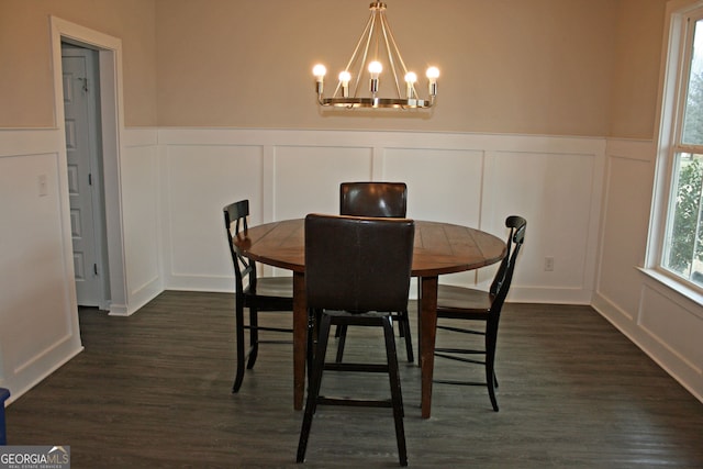 dining area featuring dark hardwood / wood-style flooring and an inviting chandelier