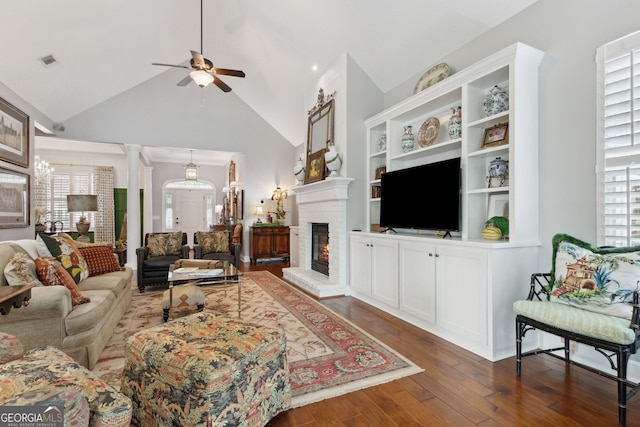 living room featuring ceiling fan, vaulted ceiling, a fireplace, and dark hardwood / wood-style flooring