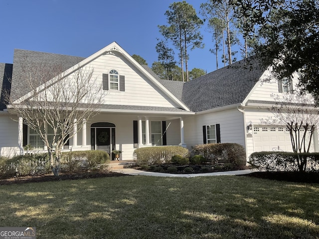 view of front of house with a garage, a front lawn, a porch, and a shingled roof