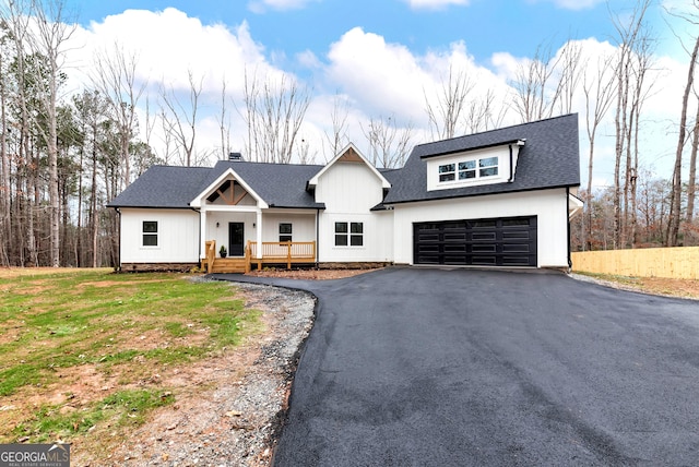 modern inspired farmhouse featuring a garage and a front lawn